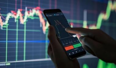 Hands holding a phone displaying a graph