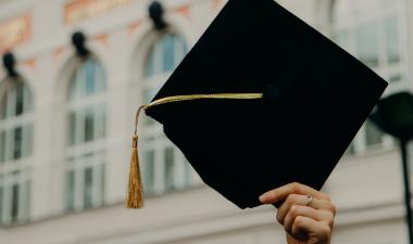 Someone holding up a graduation cap