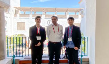 Three students who participated in a research competition pose outdoors. 