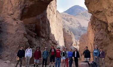 Students pose in front of a rock formation in Death Valley National Park.