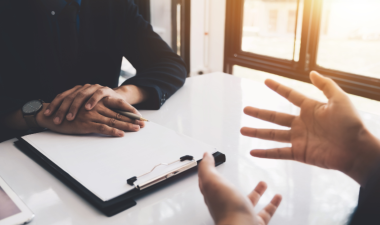 Two people seated at a table and talking