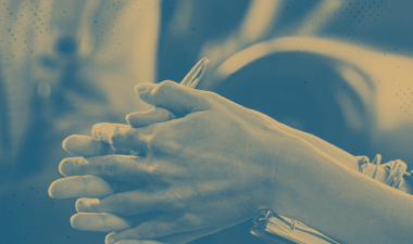 Hands are resting on a notebook.