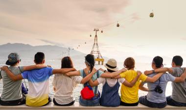 people holding shoulders sitting on a wal
