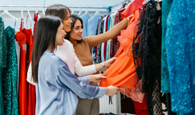 3 people looking at clothes on a clothes rack