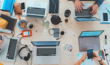 people sitting down at a table with computers
