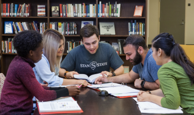5 students at a table studying
