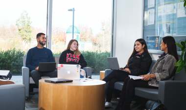 Four students studying inside a classroom building.