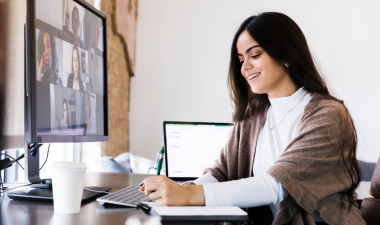 a woman sitting at a desk in a virtual conference