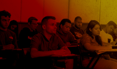 Duotone image of students inside a classroom.