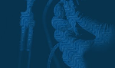 Duotone image of hands adjusting medical equipment.