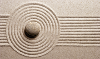 a zen garden of sand with a rock in the center