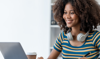 Student sits at a desk working on her laptop computer.