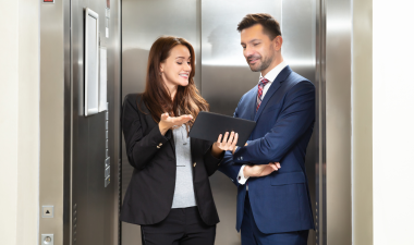 two people talking inside an elevator.
