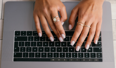 Hands typing on a laptop keyboard.
