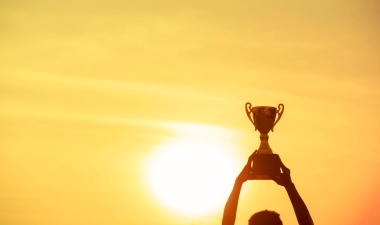 a man holding a trophy up to the sky.