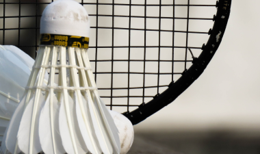 a badminton birdie in front of a racket.