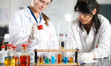 two scientists examining beakers in a chemistry lab