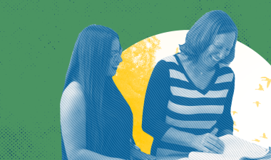 Two women talking and looking at a book