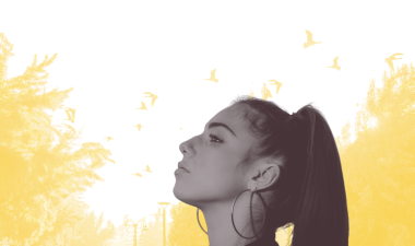 Student looking up in front of campus landscape.