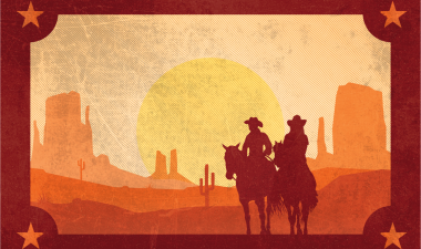 The outline of two cowboys against the backdrop of a setting sun.