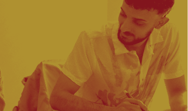 Student with pen and paper sits at a desk.
