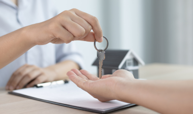 A person handing keys to another person