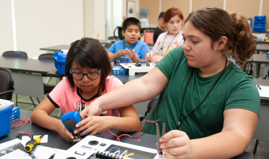 Two students assemble as solar suitcase during a summer camp at Stan State.