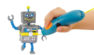 A hand using a blue 3D printing pen to create a small, colorful robot figure.