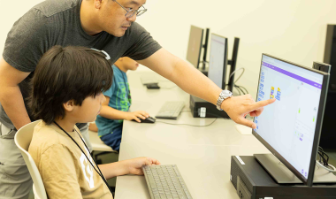 Kyu Han Koh and an elementary school student at summer coding camp.