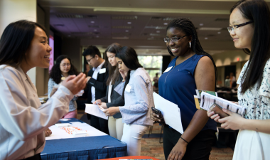 A diverse group of individuals gathered around a table, engaging in discussion.