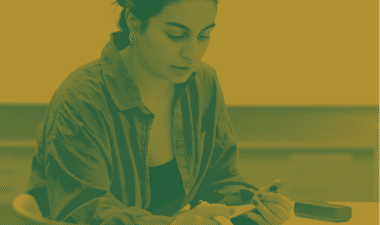 Student seated at a table indoors.