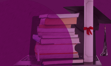 A laptop featuring a graduation cap and several books.