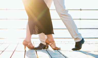 A couple engaged in a dance on a wooden deck.