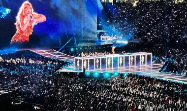 A large audience is engaged in a concert, focused on the performer on stage.