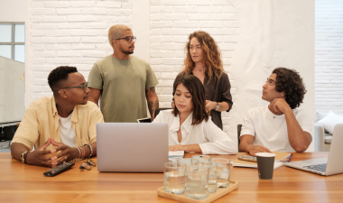 A group of diverse employees work in a group setting.