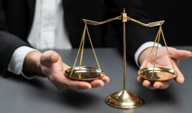 A set of hands holds a scale with two weights