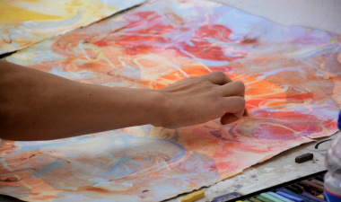 Student painting with oil pastel colors.