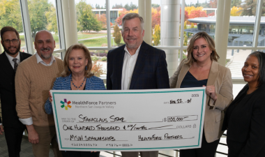 A group of university officials proudly hold the celebratory check donated by HealthForce Partners