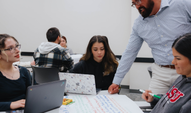 An instructor assists students during a group exercise