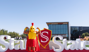 Titus standing in front of the Stan State sign in front of the University Student Center