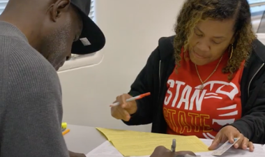 A Stan State student assists a community member with their income tax return.