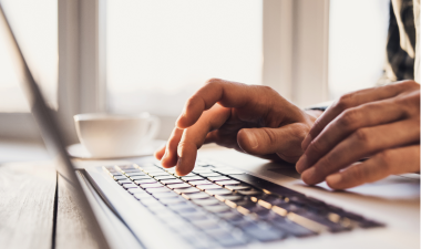Hands typing on a computer