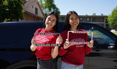 Stan State students holding license plate frames.