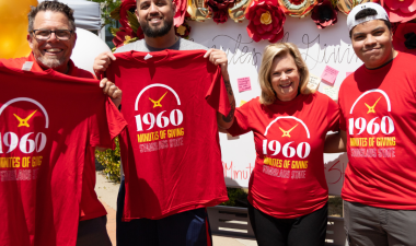 President Britt Rios-Ellis poses for a photo alongside 3 community members at the 1960 campaign event.