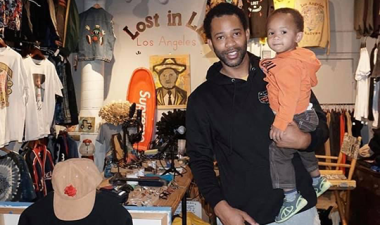 Joel Stallworth holds his child while standing inside 