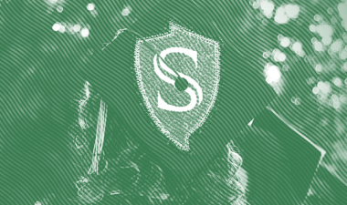 Student wearing a mortar board with the Stan State shield logo.