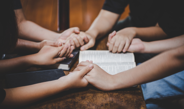 Group holding hands and praying