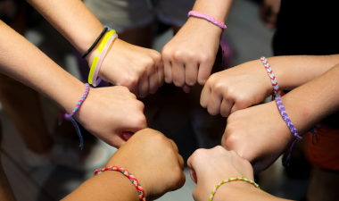 People, with bracelets on, putting their hands together