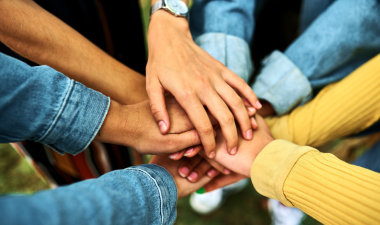 People huddling and touching hands