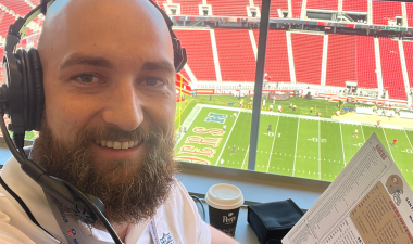 Steven Flowers holding up a statistics sheet in the press box of Levi's Stadium.